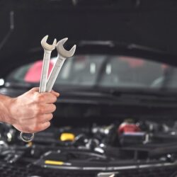 mechanic-holding-pair-wrenches-repair-garage_146671-19612