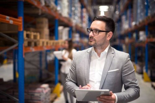 portrait-successful-businessman-manager-ceo-holding-tablet-walking-through-warehouse-storage-area-looking-towards-shelves (1) portrait-successful-businessman-manager-ceo-holding-tablet-walking-through-warehouse-storage-area-looking-towards-shelves (1)