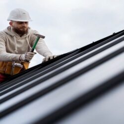 man-working-roof-with-hammer-full-shot
