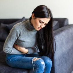 sick-woman-having-stomachache-living-room_optimized_250