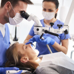 male-dentist-working-with-dental-microscope_1_optimized_100